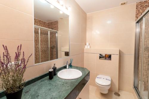 a bathroom with a sink and a toilet and a mirror at RentitSpain - Almuñecar - Vistas Increíbles al mar en Apartamentos Lambda in Almuñécar