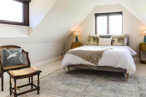 a bedroom with a bed and a chair at Herons Nest in Ripple
