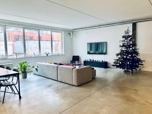 een woonkamer met een kerstboom en een bank bij Loft Antwerp - Eilandje in Antwerpen