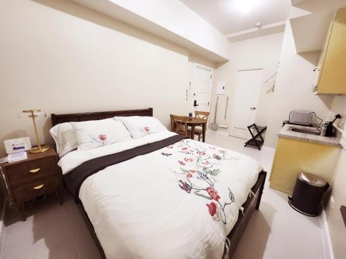 a bedroom with a large bed and a kitchen at KL Tower Condo, Makati City in Manila