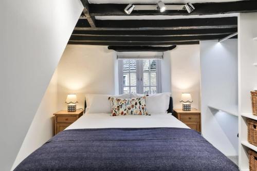 um quarto com uma cama grande e 2 candeeiros em Alexis Cottage Tetbury Cotswolds em Tetbury