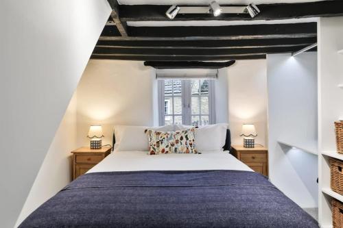 une chambre avec un grand lit et deux lampes dans l'établissement Alexis Cottage Tetbury Cotswolds, à Tetbury
