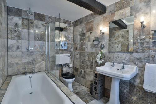a bathroom with a tub and a sink and a toilet at Alexis Cottage Tetbury Cotswolds in Tetbury