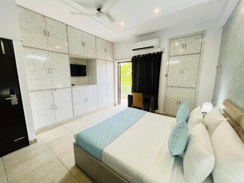 een slaapkamer met een groot bed en een televisie bij Comfort stay Noida sector 19 in Noida