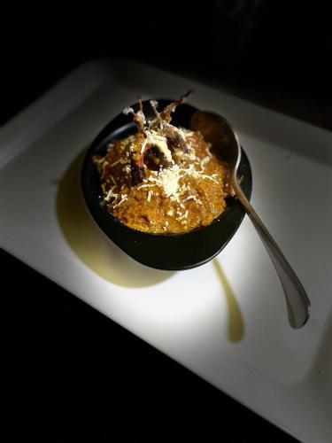 a bowl of food on a plate with a spoon at Anjali Delux in Kalimpong