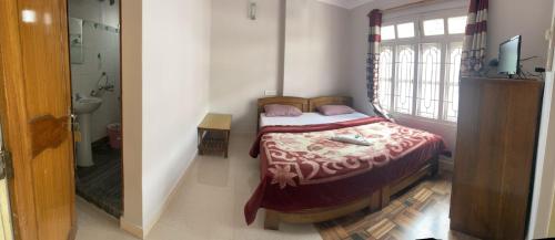 a small bedroom with a bed and a window at Anjali Delux in Kalimpong