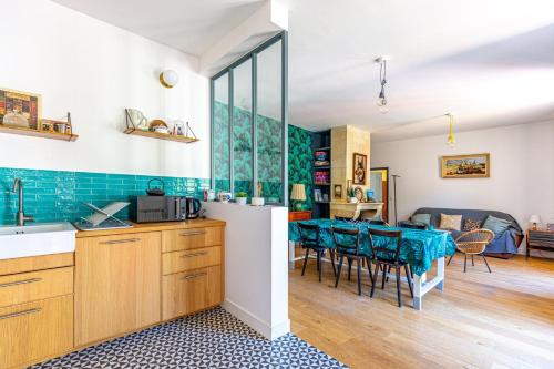 une cuisine et un salon avec une table et des chaises dans l'établissement La Dépendance - Piscine & Jardin dans Bordeaux, à Bordeaux