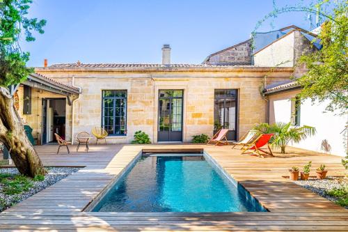 une maison avec une piscine et une terrasse en bois dans l'établissement La Dépendance - Piscine & Jardin dans Bordeaux, à Bordeaux