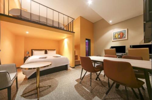 um quarto de hotel com uma cama, uma mesa e cadeiras em Incheon Browndot Hotel Nonhyeon Soraepogu em Incheon