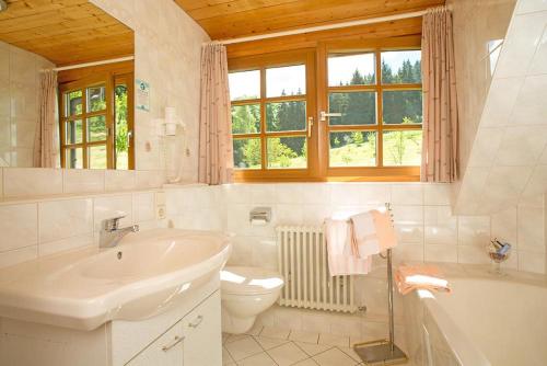 a white bathroom with a sink and a toilet at Ferienhaus Esche in Hinterzarten