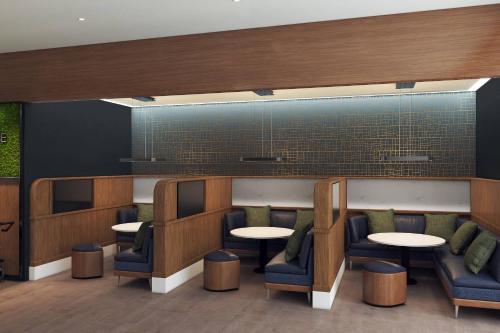 a waiting room with tables and chairs at Courtyard by Marriott Hamilton in Hamilton