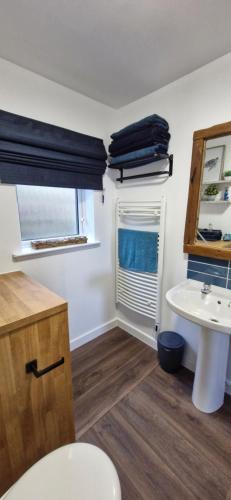 a bathroom with a sink and a toilet and a window at Seaview cosy 2 bed home in Lamlash in Lamlash