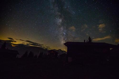 a starry night with a house and the milky way at Alphütte Bielerhüs in Fiesch
