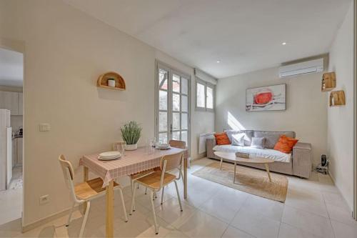 un salon avec une table et un canapé dans l'établissement TopTip - CLiM - Terrasse - Wi-Fi -Parking gratuit en souterrain, à Avignon
