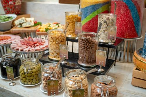 a table with many jars of food and other foods at The Oriental Jade Hotel in Hanoi