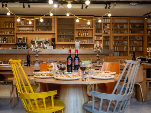 a table in a restaurant with chairs and wine bottles at MOB HOTEL Paris Les Puces in Saint-Ouen