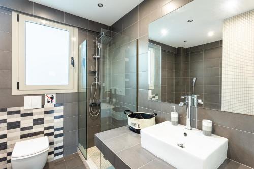 a bathroom with a sink and a toilet and a mirror at Beachfront Artemida Retreat - Peony Seabreeze Gem in Artemida