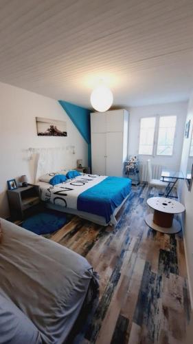 a bedroom with two beds with blue sheets and a table at MAISON MER LA NOE in Saint-Cast-le-Guildo