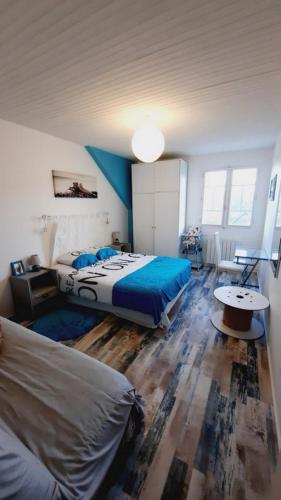 - une chambre avec 2 lits avec des draps bleus et une table dans l'établissement MAISON VACANCES VUE MER 500 m PLAGE, à Saint-Cast-le-Guildo