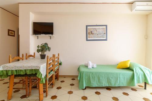 uma sala de jantar com duas mesas e uma televisão em Villa Cavallaro em Giardini Naxos