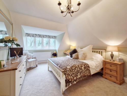 a bedroom with a bed and a desk and a television at Squirrels Holt in Chichester