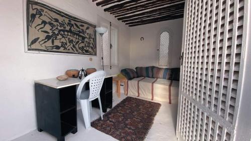 Dar Essarouel Hammamet في الحمامات: غرفة بها مكتب وكرسي وأريكة