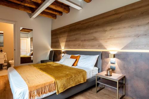 - une chambre avec un grand lit et un mur en bois dans l'établissement Pepenero Camera con Vista, à Pavia dʼUdine