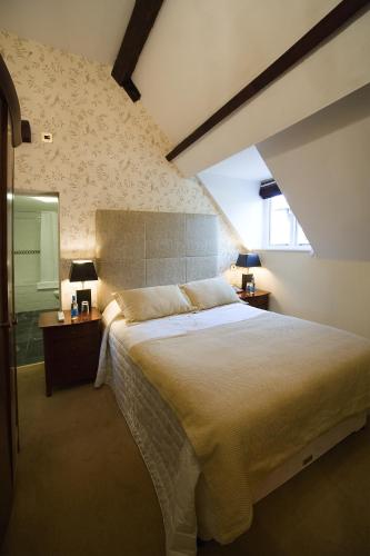 a bedroom with a large bed and a mirror at Colwick Hall Hotel in Nottingham