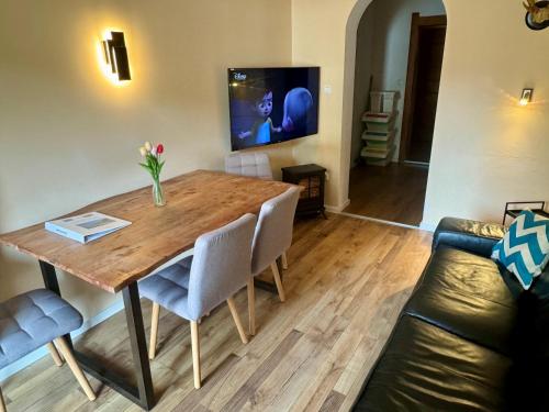 a living room with a wooden table and a couch at Familienurlaub mit Baden & Berge, FeWo 2 in Thiersee