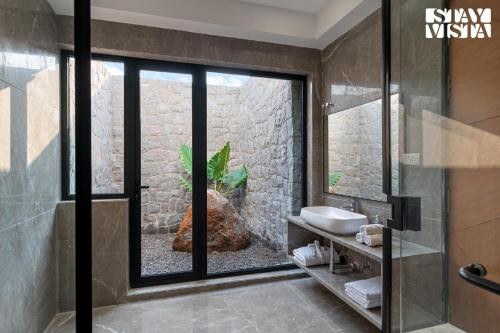a bathroom with a shower and a sink and a window at StayVista at AJ House with Pvt Pool & Projector Set-up in Hyderabad