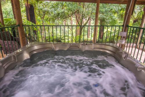 bañera de hidromasaje con agua en el balcón en The Fernglen Forest Retreat en Mount Dandenong