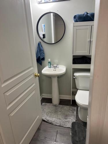 W łazience znajduje się umywalka, toaleta i lustro. w obiekcie Elegant Private Room w mieście Oshawa