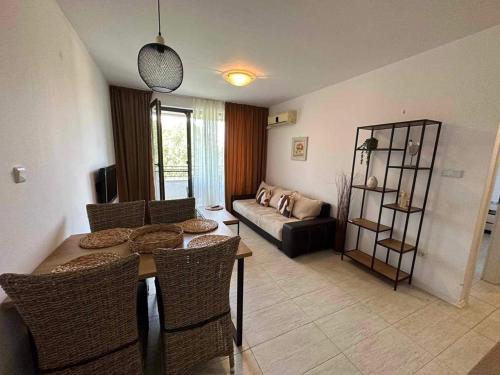 ソゾポルにあるNiya Apartments Kavaci Sozopolのテーブルと椅子とソファのあるリビングルーム