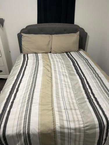 1 cama con edredón blanco y negro y 2 almohadas en Elegant Private Room en Oshawa