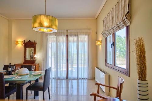 a dining room with a table and chairs and a window at Utopia Beach Villa in Litherés