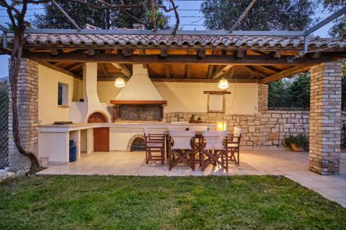 an outdoor kitchen with a table and chairs on a patio at Utopia Beach Villa in Litherés