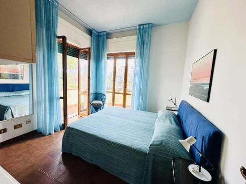 Villa del fortino, 140mq في فورتي دي مارمي: غرفة نوم بسرير ازرق وشرفة