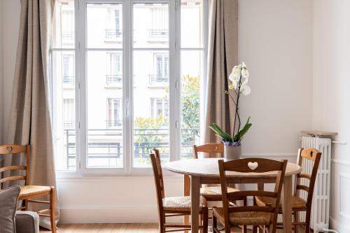 une salle à manger avec une table et une grande fenêtre dans l'établissement Veeve - Birds of Paradise, à Paris