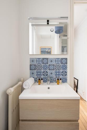 une salle de bain avec un lavabo et un miroir dans l'établissement Veeve - Birds of Paradise, à Paris