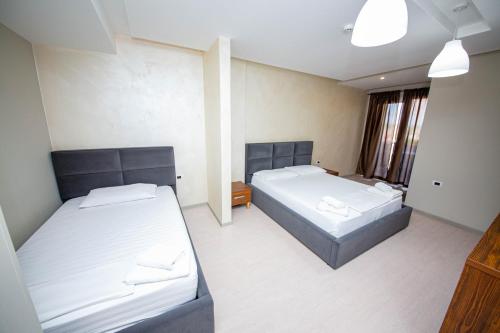 a room with two beds and a window at Hotel Miki in Durrës