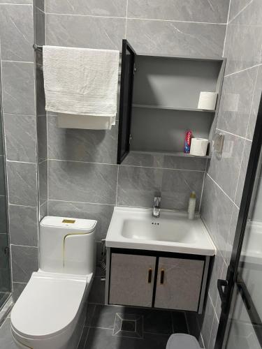a bathroom with a white toilet and a sink at Fluted Nest 16th Floor Wood Avenue- Yaya centre Kilimani in Nairobi