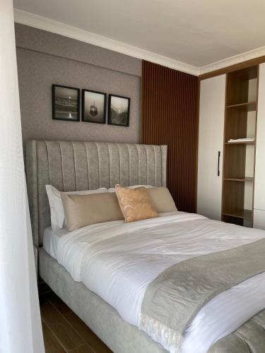 a bedroom with a large bed with white sheets at Fluted Nest 16th Floor Wood Avenue- Yaya centre Kilimani in Nairobi