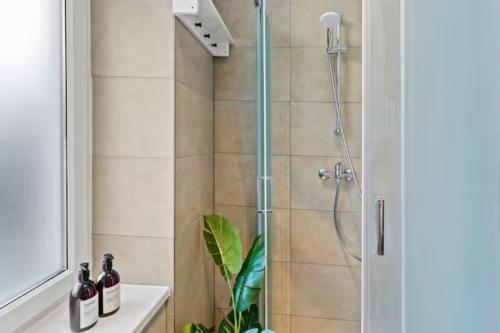 a bathroom with a shower with a glass door at Chic Vienna Apartment in Vienna