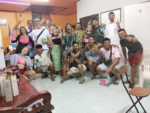 un groupe de personnes posant une photo dans une pièce dans l'établissement Funny Moon Hostel, à Haad Rin