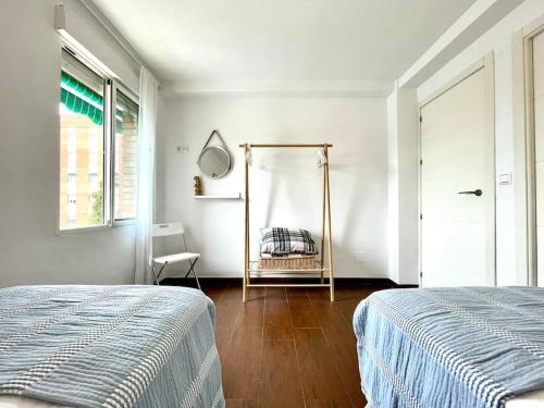 a white bedroom with a bed and a mirror at Casa Paula in Córdoba