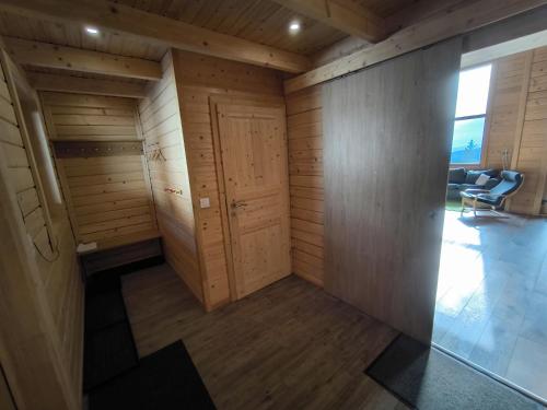 Zimmer mit Holzwänden, einer Tür und Stühlen in der Unterkunft Bergliebe Klippitztörl in Klippitztorl