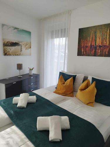 1 dormitorio con 1 cama blanca grande con almohadas amarillas en Beach Home Apartman, en Balatonfüred