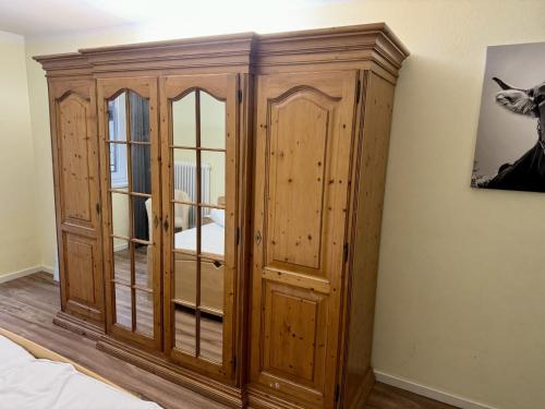 a wooden cabinet with glass doors in a bedroom at Entspannung in Tirol, Gemütliche Ferienwohnung im Thierseetal, FeWo 14 in Thiersee