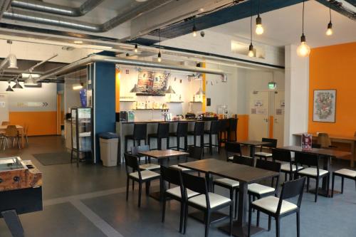 un restaurante con mesas y sillas y un bar en CheapSleep Hostel Helsinki en Helsinki