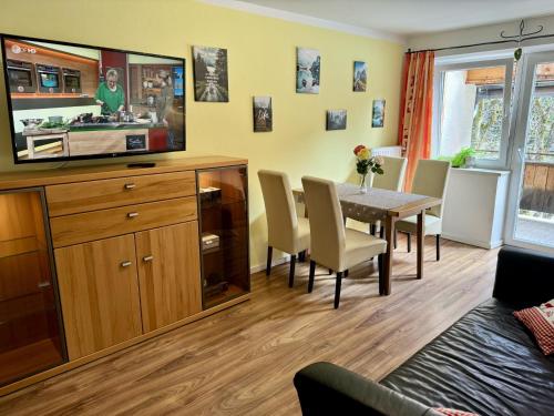 a kitchen and dining room with a table and a television at Urlaub mit Hund im Familienparadies MoNi, FeWo 15 in Thiersee